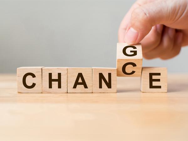 wooden blocks spelling out the word 'CHANGE' the letter G is tilted by a person to make the word read as 'CHANCE'