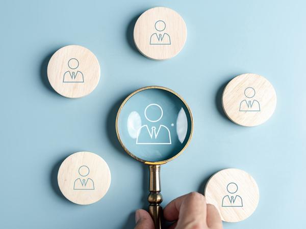 5 wooden circles showing a person wearing a shirt and tie, in the centre is a small magnifying glass - inside this is another person wearing a shirt and tie. 