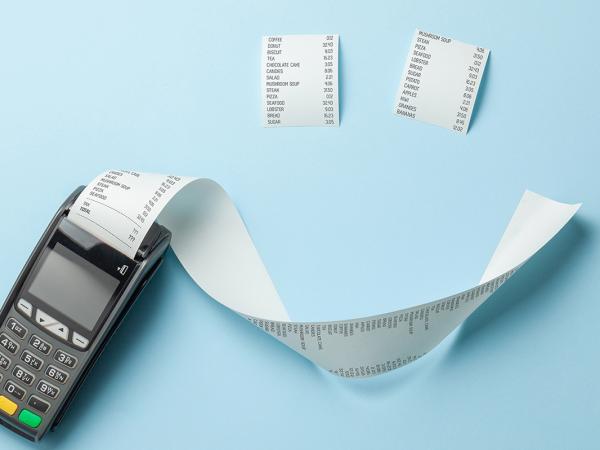 A till roll printing a long receipt and 2 smaller receipts arranged to look like a smiley face on a pale blue background