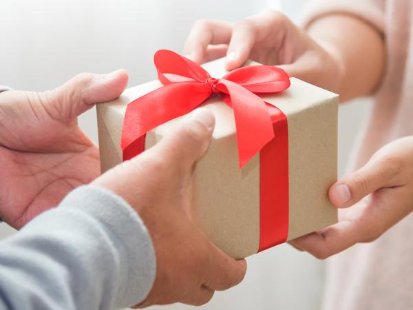 a person handing a gift to someone else. 