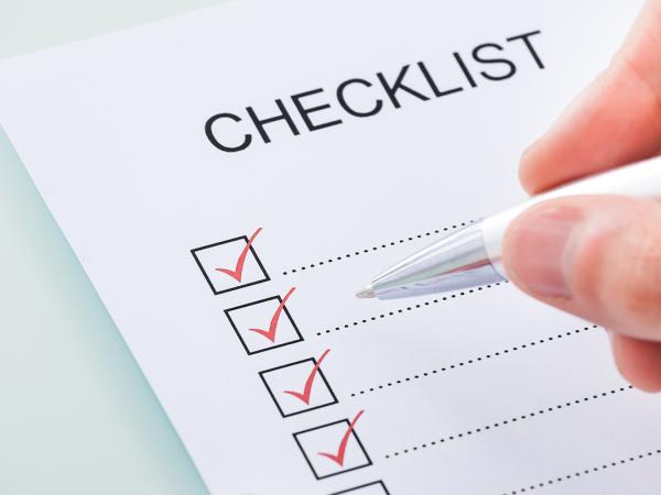 a piece of white paper titled 'CHECKLIST' down the left side are boxes with a red tick in each one. 