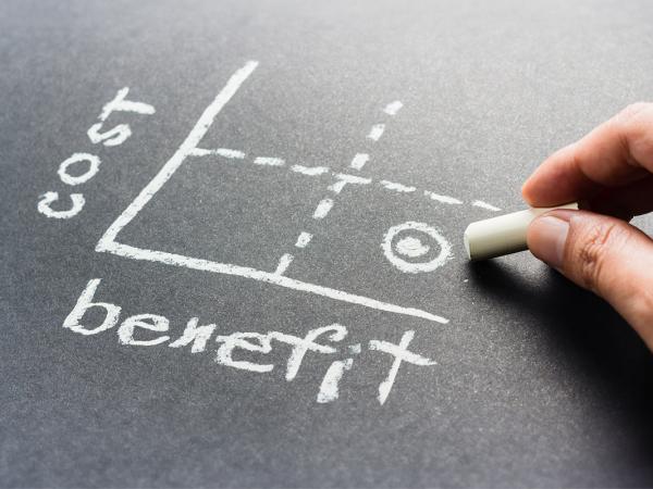 a graph drawn on a chalkboard, one side stating 'BENEFITS' the other stating 'COST' 