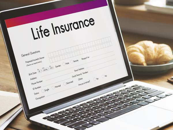 a laptop with a screen loaded up showing a form to fill in with the words 'LIFE INSURANCE' at the top.