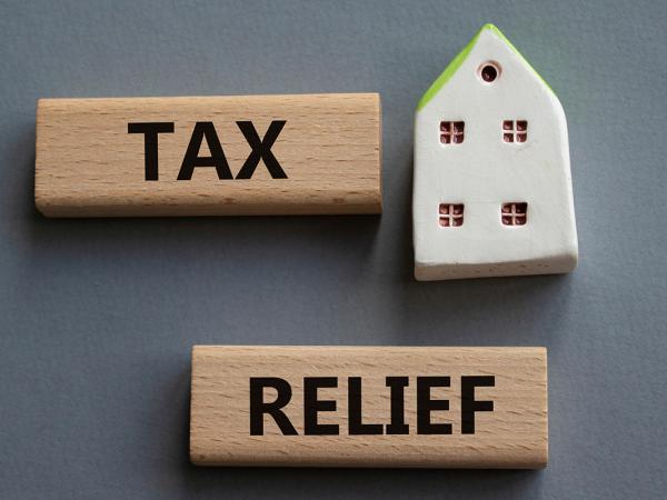 wooden blocks spelling out 'TAX RELIEF' and a figure of a house