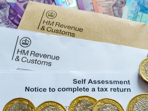 A letter from HMRC with the words 'SELF ASSESSMENT NOTICE TO COMPLETE A TAX RETURN' on the top, surrounded by British currency