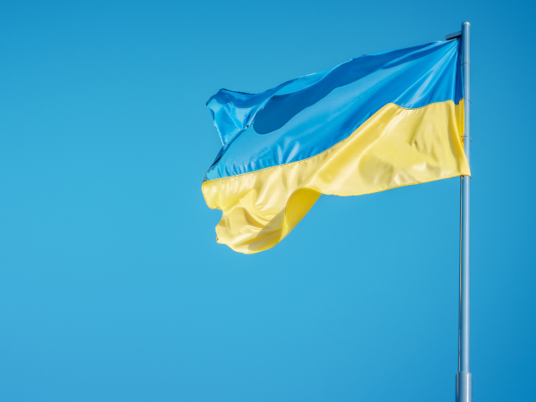 a blue sky with a Ukrainian flag blowing in the wind. 