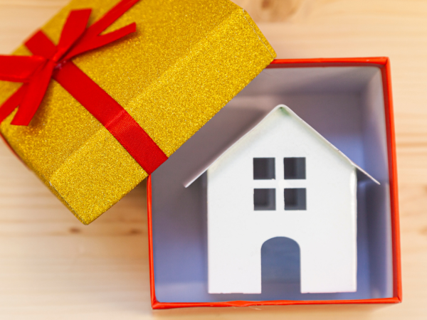 A gift box containing a small model house.