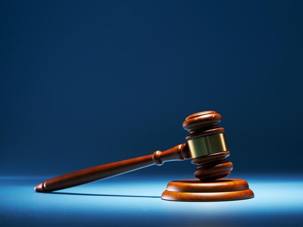 A blue background with a spotlight highlighting a gavel.