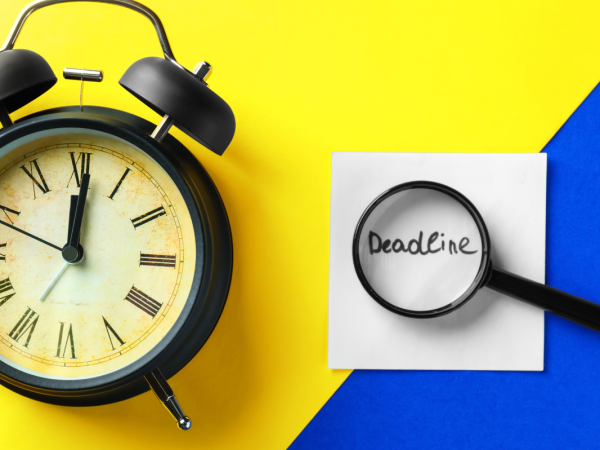Yellow and blue background with a clock and a magnifying glass hovering over the word 'DEADLINE'. 