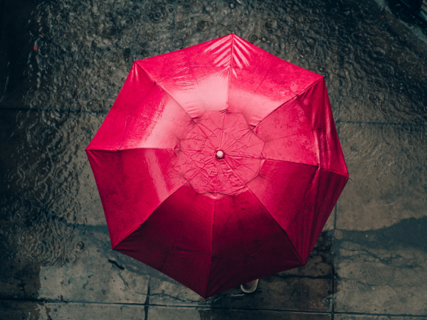 A dark street with a red umbrella. 