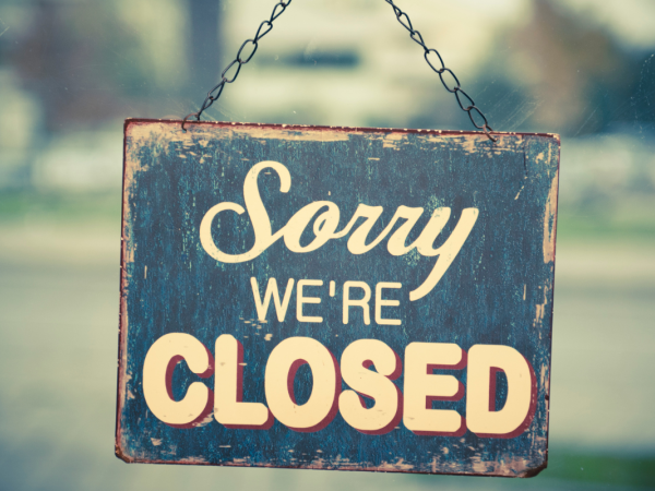 A sign hanging on a door that reads 'SORRY WE'RE CLOSED'. 