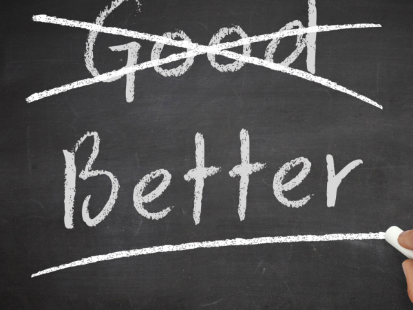 Chalkboard with the words 'GOOD' and 'BETTER' the word 'GOOD' has been crossed through 