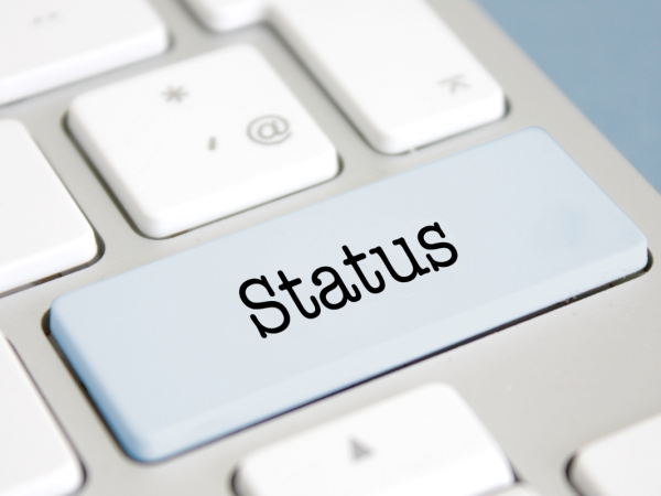 A computer keyboard with one key a different colour, this key has the word 'STATUS' on it. 