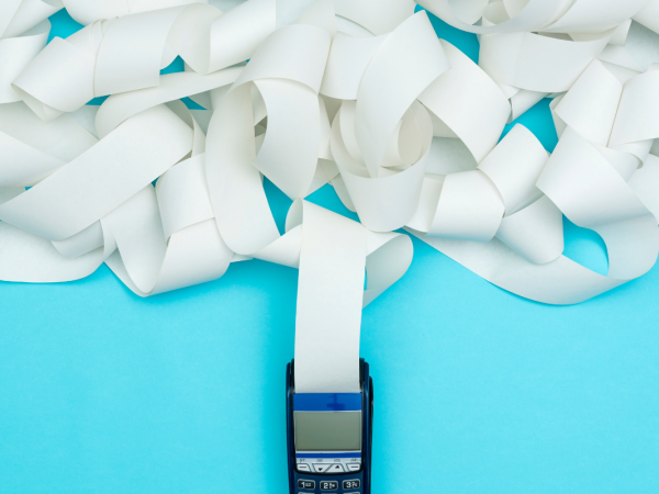 A card payment machine with a lot of paper coming out of it