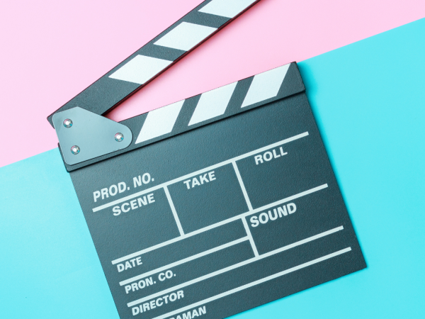 Clapperboard against a pink and blue background