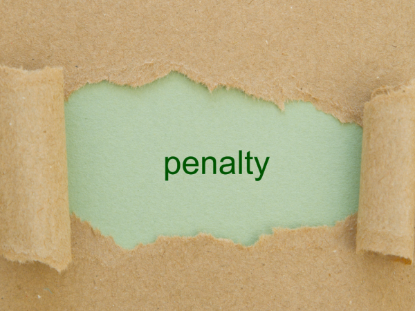A piece of brown paper with a tear in the center, through the tear a green sheet of paper with the word 'PENALTY' can be seen.
