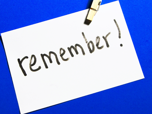 A white card with the word 'REMEMBER!' written in black pen against a bright blue background.