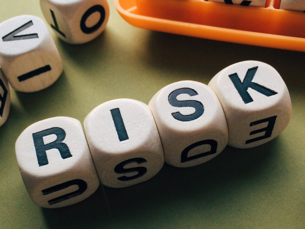 wooden cubes each containing a letter - together spells out the word 'RISK' 