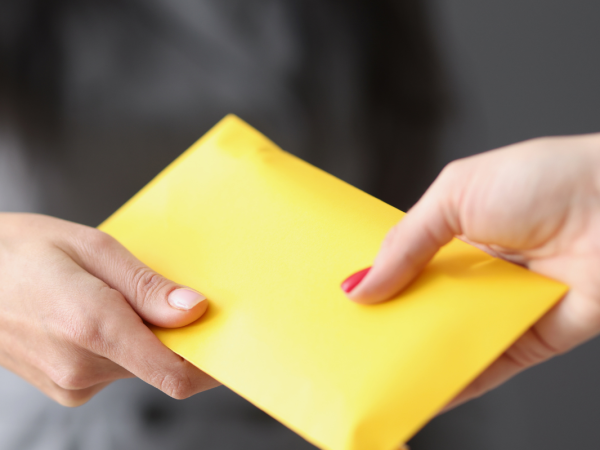 an employer handing an envelope to an employee