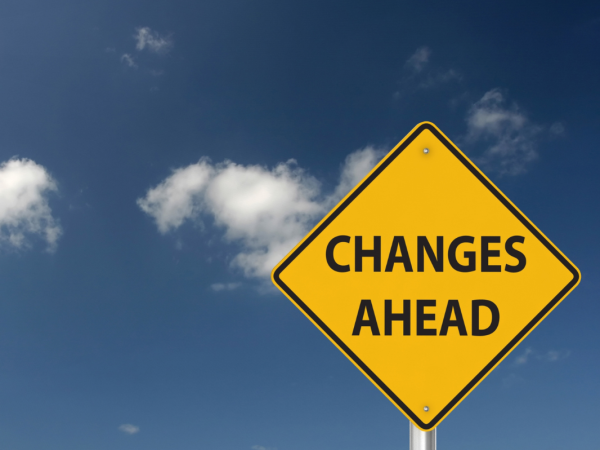 A yellow road sign with the words 'CHANGES AHEAD' in black text against a blue sky background.