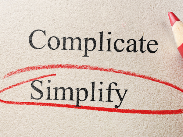 two words typed on a piece of paper 'COMPLICATE' and 'SIMPLIFY' the word 'SIMPLIFY' is circled in red pencil.