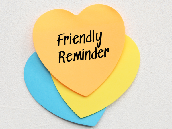 3 colourful pieces of paper cut into heart shapes, the top one reads 'FRIENDLY REMINDER' in black ink. 