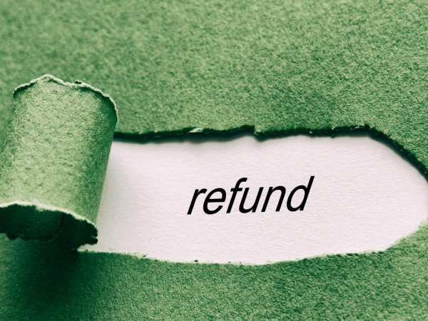 A green piece of paper with a tear in it revealing a white paper beneath, the white paper seen through the rip has the word 'REFUND' typed on it. 