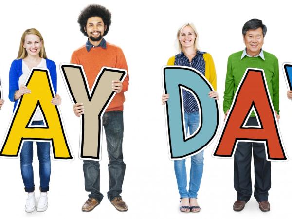 People holding letters spelling pay day