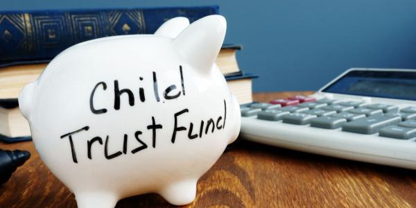 white piggy bank with the words 'CHILD TRUST FUND' written in black ink.