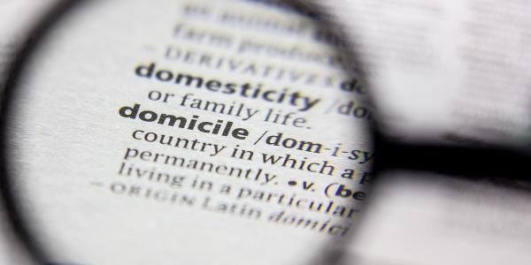 The dictionay definition of 'DOMICILE' being looked at through a magnifying glass.