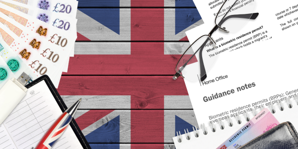 UK flag painted in the background, on top of this various things can be seen, English money, clipboard and pen, USB drive, glasses, residence permit and 'GUIDANCE NOTES' documents