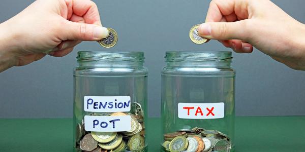 Two glass jars with stickers on them, one says 'PENSION POT' and the other says 'TAX'. A person is putting money into both jars