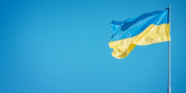 a blue sky with a Ukrainian flag blowing in the wind. 