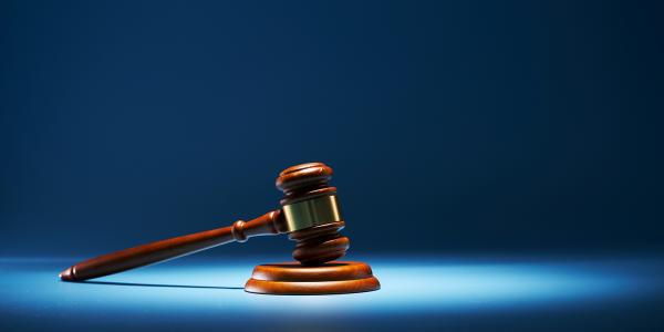 A blue background with a spotlight highlighting a gavel.