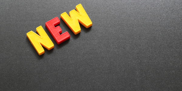 Grey background with plastic letters spelling the word 'NEW' 