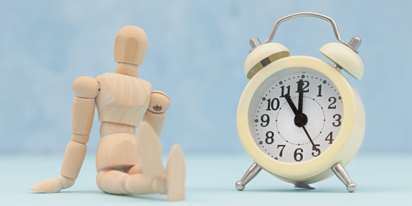 A figurine of a person sat next to a clock
