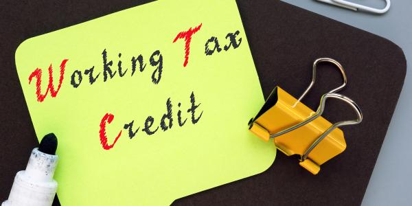 A yellow piece of paper with the words 'WORKING TAX CREDIT' written on it with black and red ink.