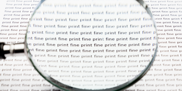 A page of text repeating the words 'FINE PRINT' in black text with a magnifying glass looking over it.