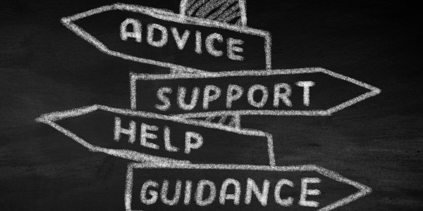 A chalkboard with a drawing of a street sign there are 4 signs that read 'ADVICE', 'SUPPORT', 'HELP', 'GUIDANCE'